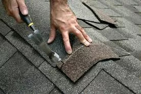 Pitcure of person nailing roofing tiles to roof