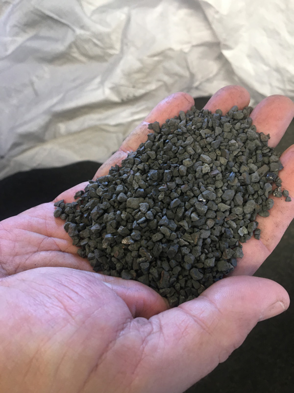 Hand holding a small amount of Sharpshot Iron Aggregate